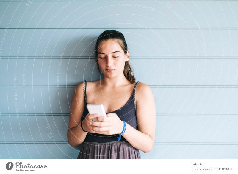 Beautiful young woman leaning on wall using a smartphone Lifestyle Happy Summer Telephone Cellphone PDA Technology Human being Feminine Young woman