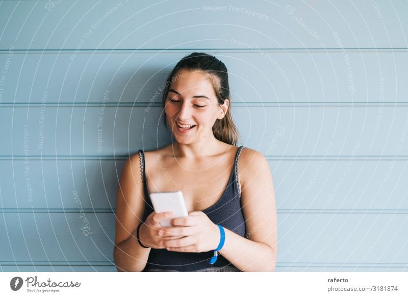 young woman leaning on a wood wall while using a smartphone Lifestyle Happy Beautiful Summer Telephone Cellphone PDA Technology Human being Feminine Young woman