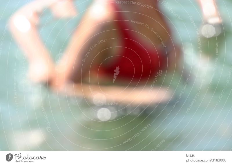 Woman in a red bikini on holiday by the sea, swimming in blue, fresh water. Adults run in the glittering, sparkling waves in the turquoise water while resting, relaxing and resting. Colourful, summery, iridescent motion blur, long exposure