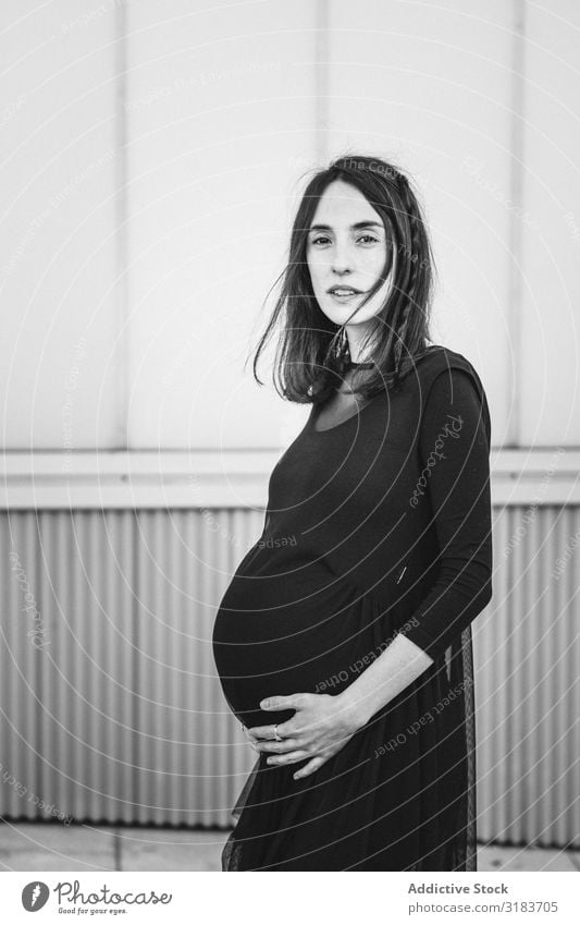 Pregnant woman standing on city street Woman Street City Pavement Touch Showing one's bellybutton Adults maternity To enjoy Lifestyle expecting Healthy Mother