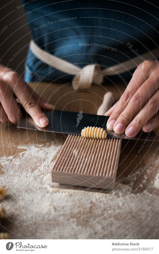 Crop woman making gnocchetti pasta Woman Pasta cutting Dough Preparation Italian Table Kitchen Home-made Tradition Raw Food wood tool Cooking recipe Ingredients