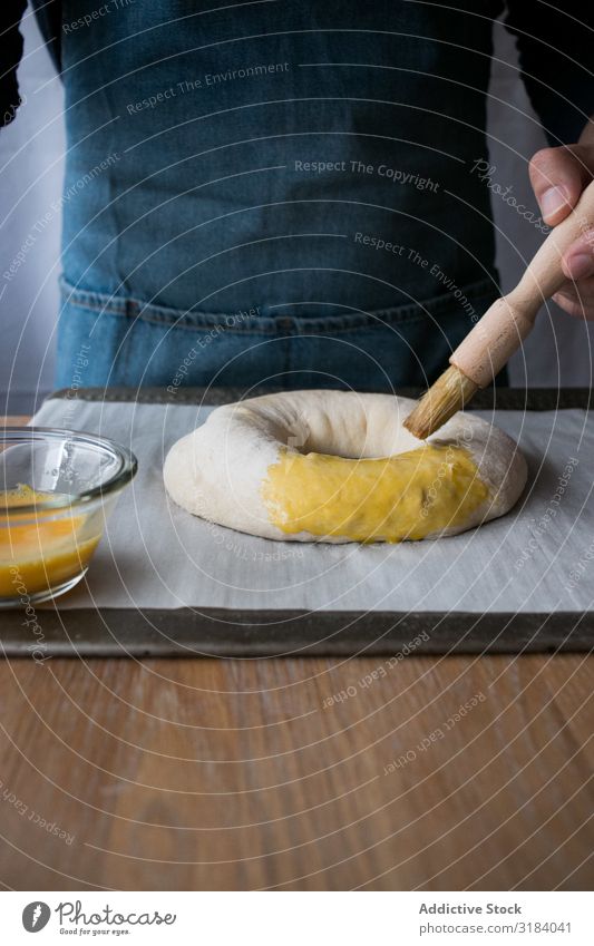 Crop cook smearing Rosca de Reyes with egg Cook Dough rosca de reyes Egg Yolk Daub Brush Baked goods Tradition Spanish Bakery Table Food Bread Ingredients