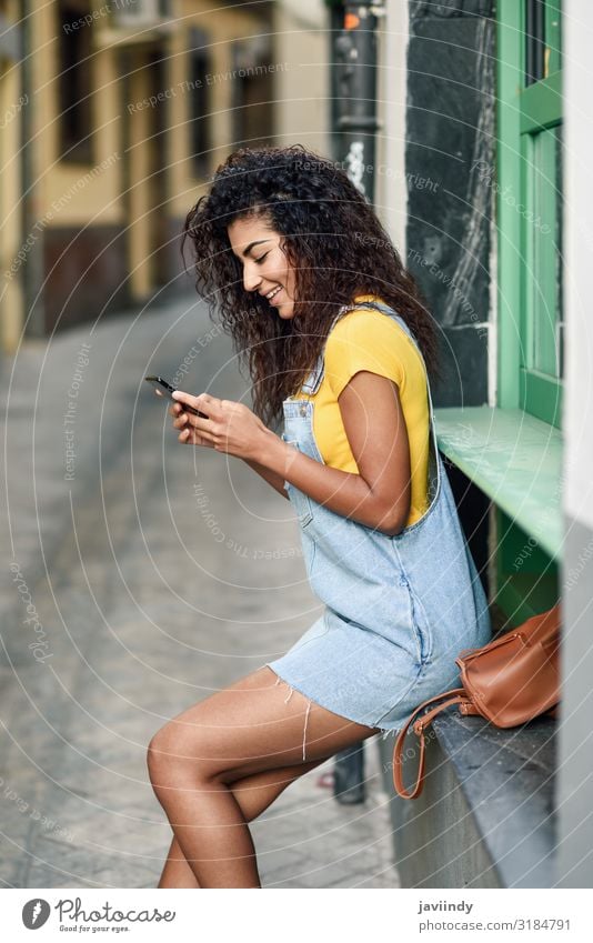 Young Arab girl looking at her smart phone outdoors Lifestyle Style Happy Beautiful Hair and hairstyles Telephone PDA Technology Human being Feminine