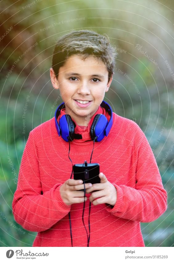 Child with dark hair listening music Joy Happy Beautiful Face Music Telephone PDA Human being Infancy Nature Landscape Fashion To enjoy Listening Smiling