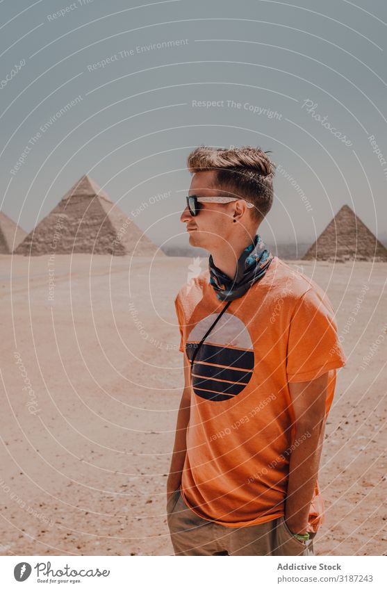 Young man against Great Pyramids traveler Egypt Man Giza Cairo Youth (Young adults) Desert Looking away Famous building Sky Beautiful weather Trip Tourism