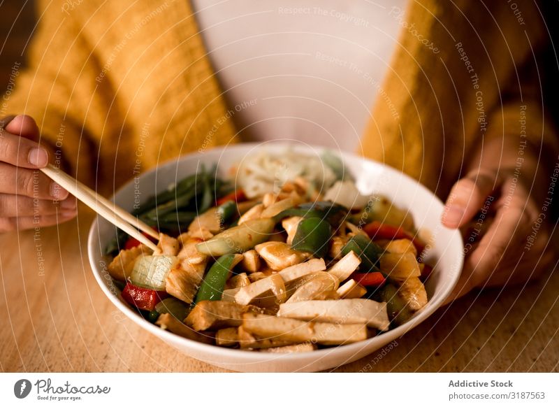 Female eating bowl of cooked appetizing diet dish Food Vegetarian diet Vegetable Carrot Onion bell pepper Mushroom Chopstick Bowl asian Café Restaurant Woman