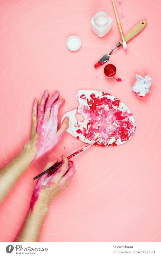 Woman's hands covered in paint and artist's supplies on pink Drawing Design Adults Artist Body Brush Conceptual design Creativity Painting and drawing (object)