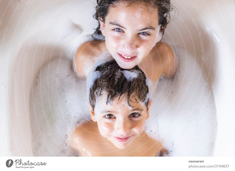 Two kids taking a bath looking a camera Lifestyle Joy Happy Beautiful Personal hygiene Body Skin Well-being Swimming & Bathing Bathtub Bathroom Child