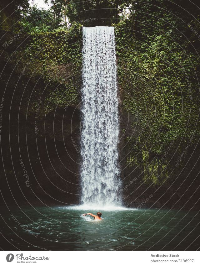 Man swimming in turquoise natural bay Float in the water Tropical Waterfall Lake Bali Bay Clear Turquoise Fresh Tourism Harmonious Vacation & Travel Summer