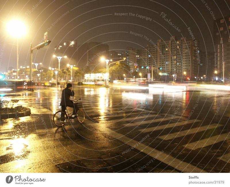 Chinese street in the rain China Bicycle Night Light Transport Reflection Zebra crossing Yellow Gray Man Crossroads Loneliness Dark Evening Moody