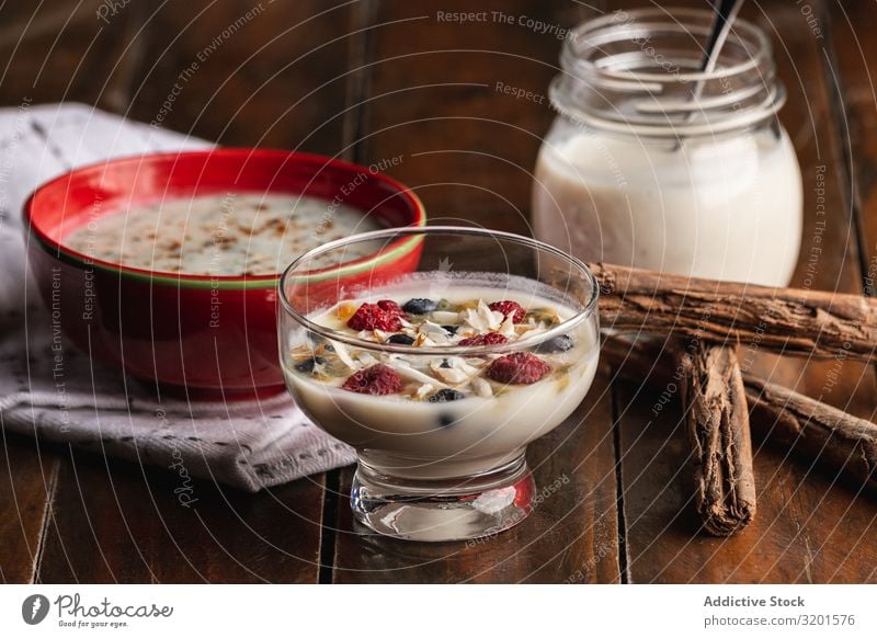 Yogurt in glass bowl with berries and cinnamon sticks Yoghurt Raspberry Redcurrant Cinnamon Berries flakes oat Fragrant Natural Vegan diet vegan milk Food