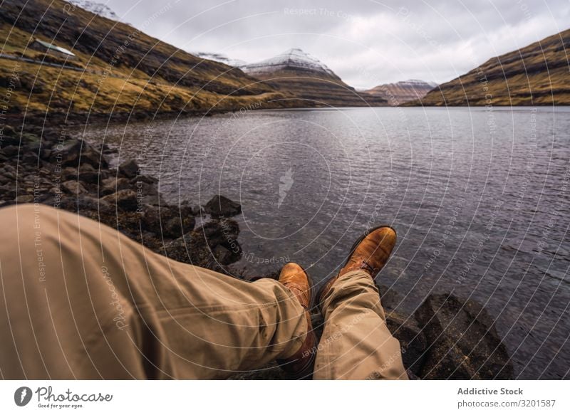 unrecognizable person sitting near lake showing legs Human being Legs Plant Coast Water Rock Stone Vantage point Picturesque Vacation & Travel Nature Sunlight