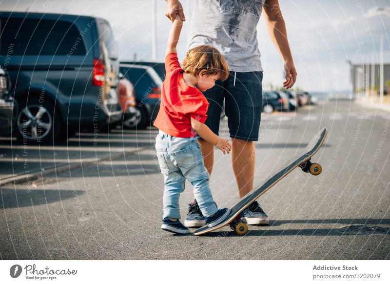 Man with kid training with skateboard Father Child Skateboard enjoying parenthood Walking Vacation & Travel Family & Relations teaching Together Joy