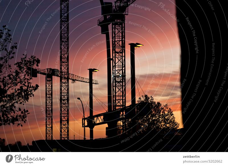 Construction site in the evening Evening slewing crane Dark Twilight Closing time Worm's-eye view large construction site Sky Heaven Industrial construction