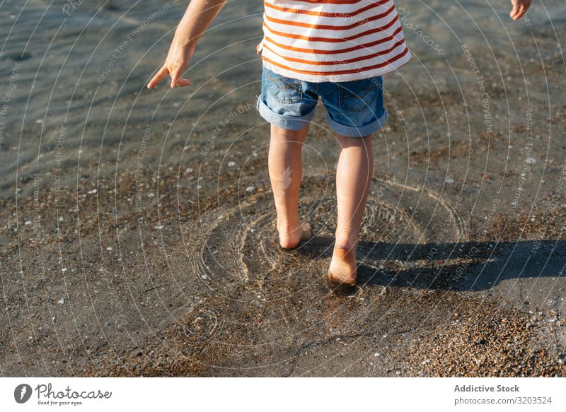 Playful little boy stepping in water Boy (child) Water Shallow Splash Summer Vacation & Travel Child Leisure and hobbies Playing Ocean Beach Small Discovery