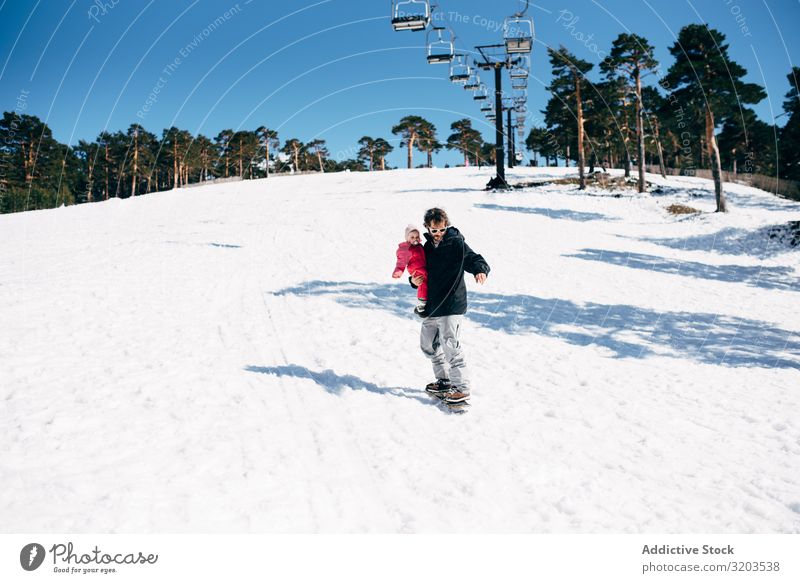 Man with daughter riding board on snow Board Snow Ride Freedom Child Nature Toddler Daughter Winter Slide Action Mountain Recklessness explore Sports Resort