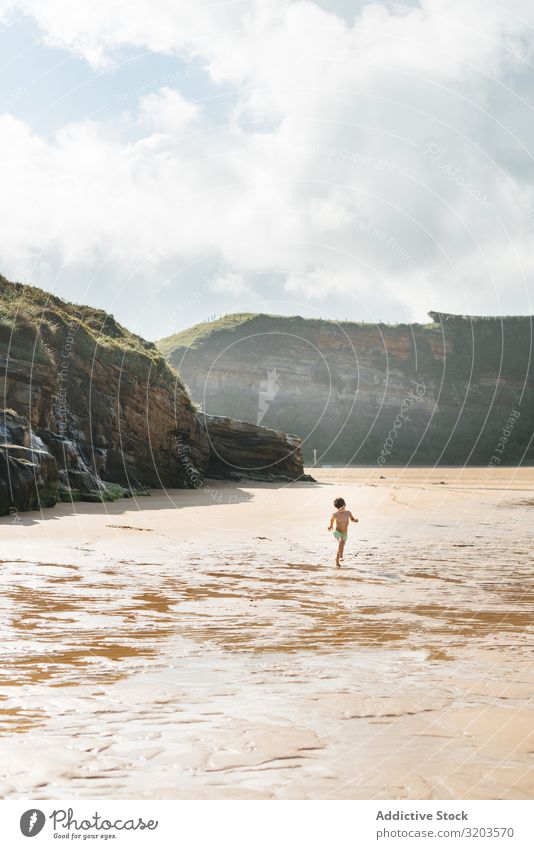 Boy kid walking on wet sunny beach Boy (child) Beach Sunlight Child Summer Coast Water Innocent Vacation & Travel Leisure and hobbies Baby Playing Rest Joy