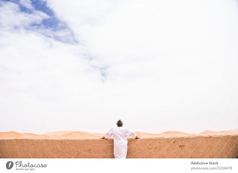 Anonymous man on terrace against desert landscape Man Desert Terrace Rear view Morocco Vacation & Travel Lean Balcony Landscape Nature White Summer Fresh Dream