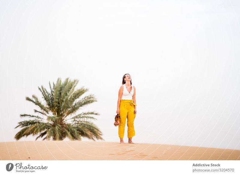 Happy woman holding shoes in desert Woman Desert Cheerful Vacation & Travel Style Guest Morocco Hip & trendy Joy Summer Beauty Photography Remote Blonde