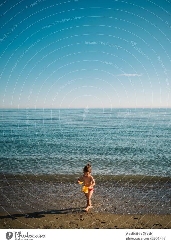 Girl playing with little stones on beach Beach Playing Stone Toddler Sand Coast Calm Ocean Sunbeam seaside Water Infancy Vacation & Travel Action Child enjoying