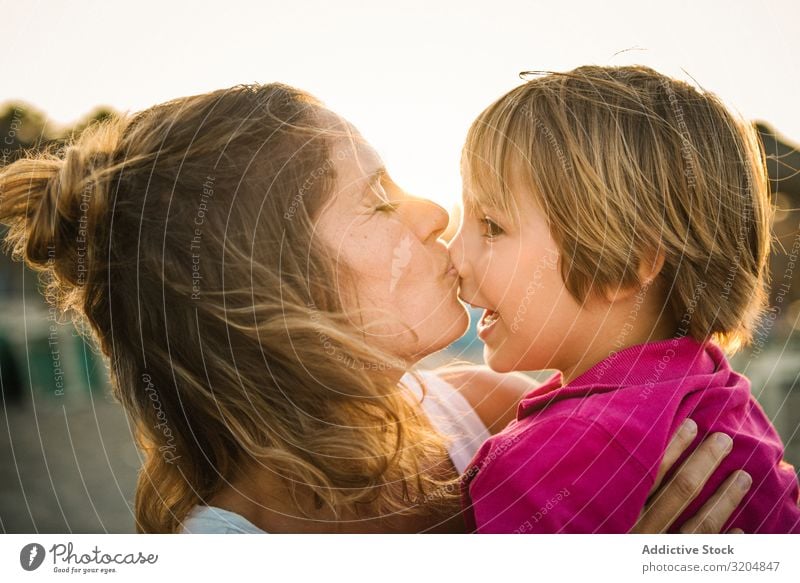 Woman with naughty boy on hands on beach Son rubbing noses Beach Joy Happy Love Vacation & Travel Mother Carrying Child Family & Relations Together Sunset