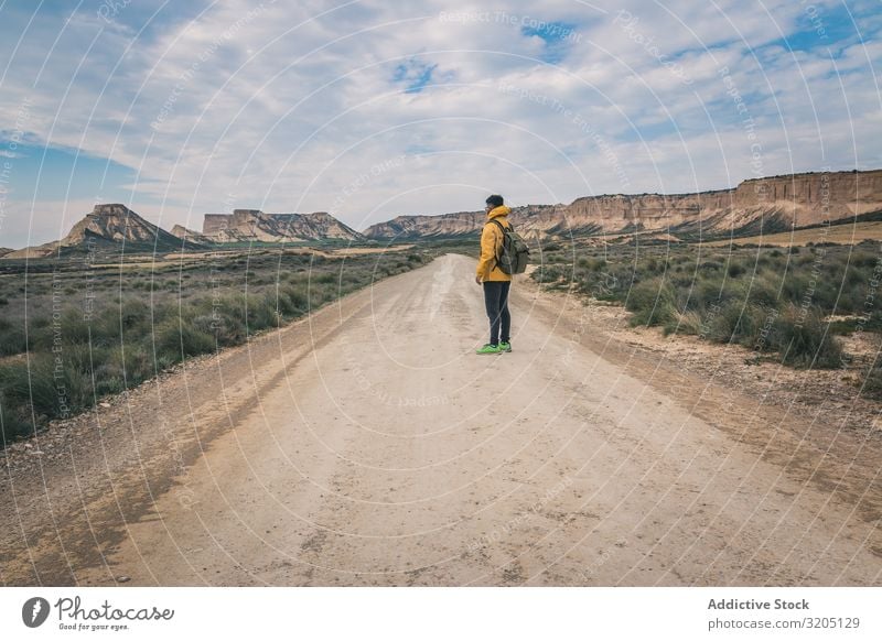 Man standing on road in desert hills Street Desert Hill Landscape Sand Stone Plant Trip Dry Nature Sky Vacation & Travel Hot Destination exploring