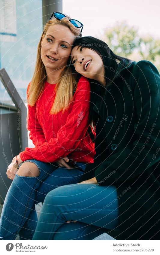 Multiethnic friends sitting on bus stop Friendship Bus stop Wait Together Smiling Lean Woman multiethnic City Street Town Cheerful Happy Lifestyle