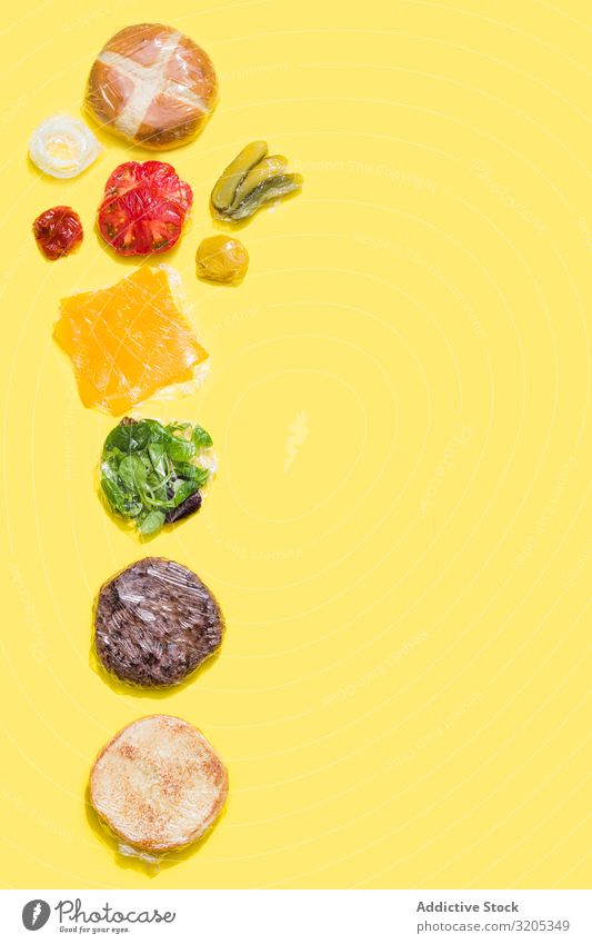 Ingredients of a cheese burger wrapped in plastic Barbecue (event) BBQ Beef Bread Roll Cheese Conceptual design flat lay Food Hamburger Ketchup Lettuce Meat