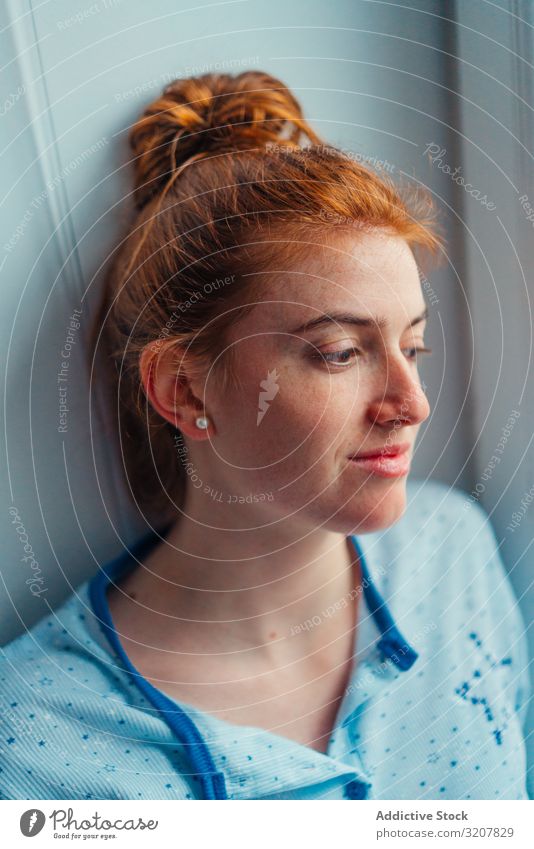 Woman sitting on window sill woman home comfort scotland young thoughtful pensive beautiful house lifestyle home clothes redhead ginger relax apartment daylight