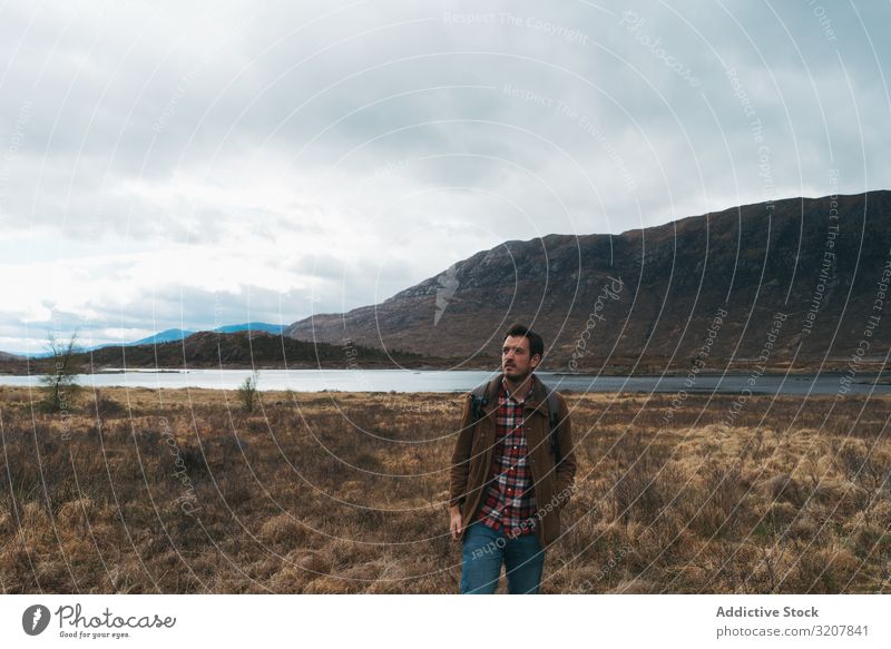 Traveling man in remote cold valley travel scotland mountain adventure backpack trekking explore nature vacation landscape lake journey freedom wanderlust