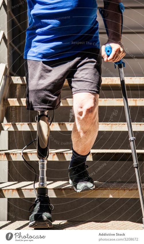 unrecognizable man amputated with crutches testing his new leg prosthesis expression disable male handicapped sit young adult amputation organ alone isolated