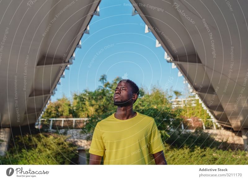 Strong black runner standing under bridge construction healthy strong architecture lifestyle workout ethnic african american summer athlete geometrical body