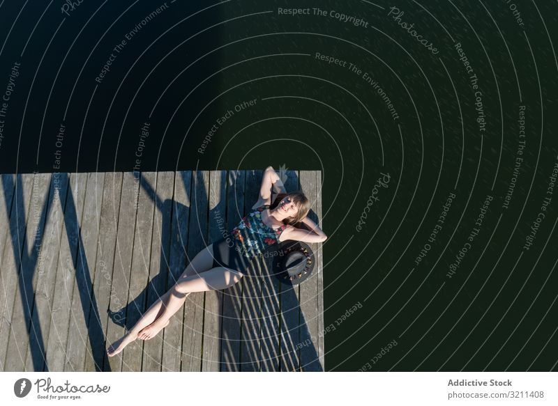 Young female lying down on pier on nature woman lake relax relaxed travel tourism rest adventure forest picturesque joy rural scenic view enjoy countryside