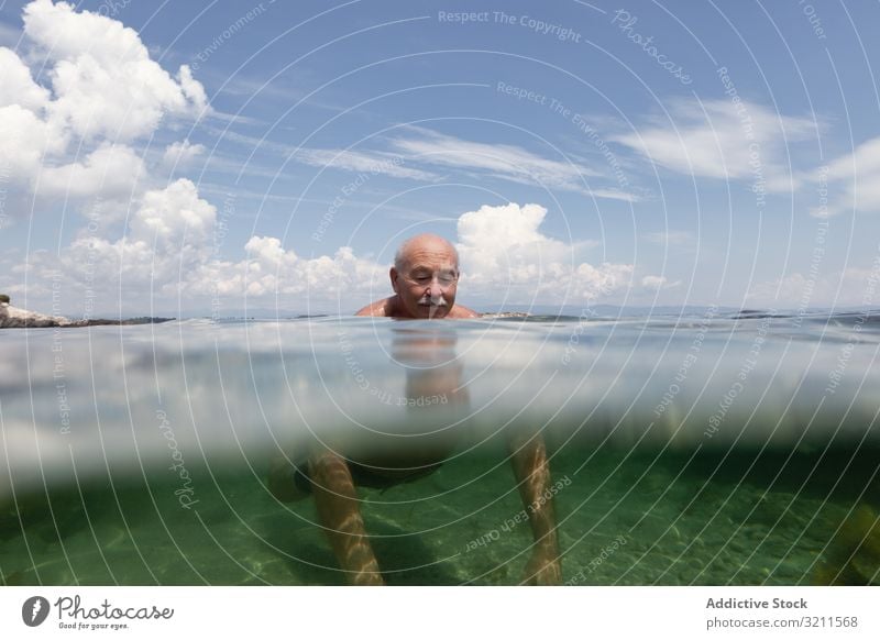 Cheerful elderly man swimming in sea water vacation senior crystal retired travel leisure greece halkidiki ocean mature happy floating nautical summer enjoy