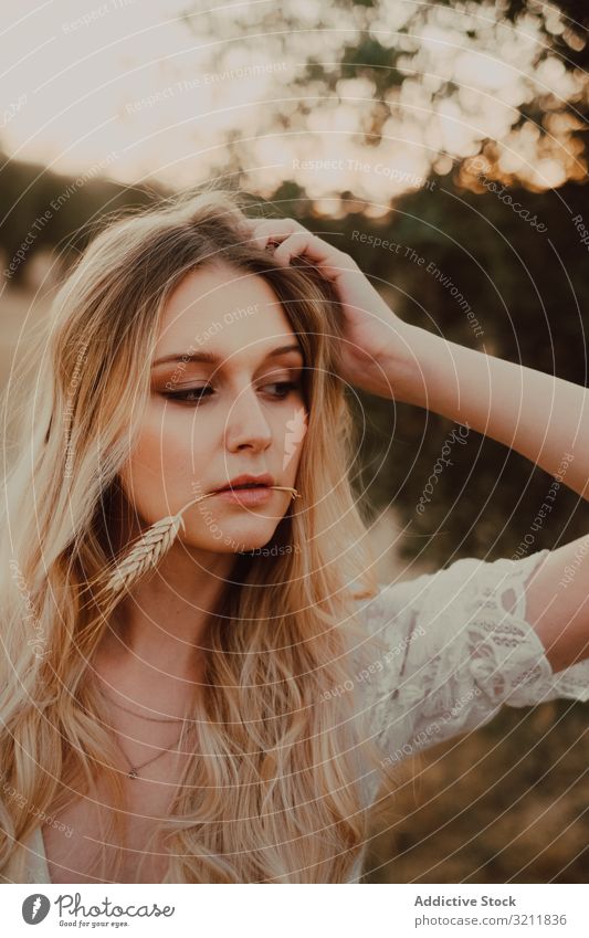 Thoughtful beautiful woman with flowing hair and straw in mouth bride boho lace dream style tender sensual natural summer romantic wedding olive tree blonde