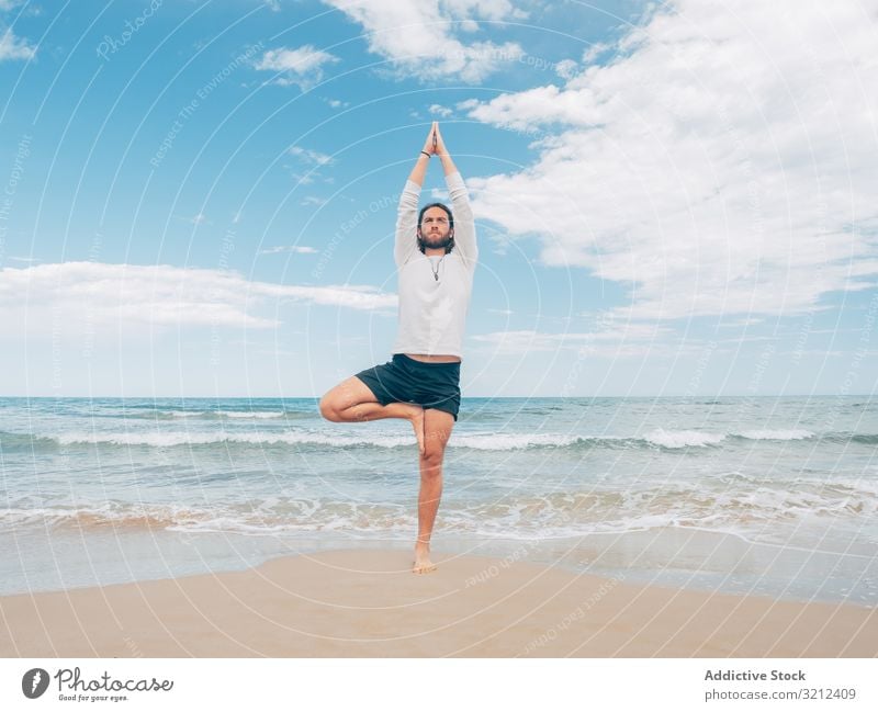 Man training yoga on beach man rest harmony asana exercise seashore energy meditation equilibrium stretch zen relax balance sport lifestyle calm male bearded