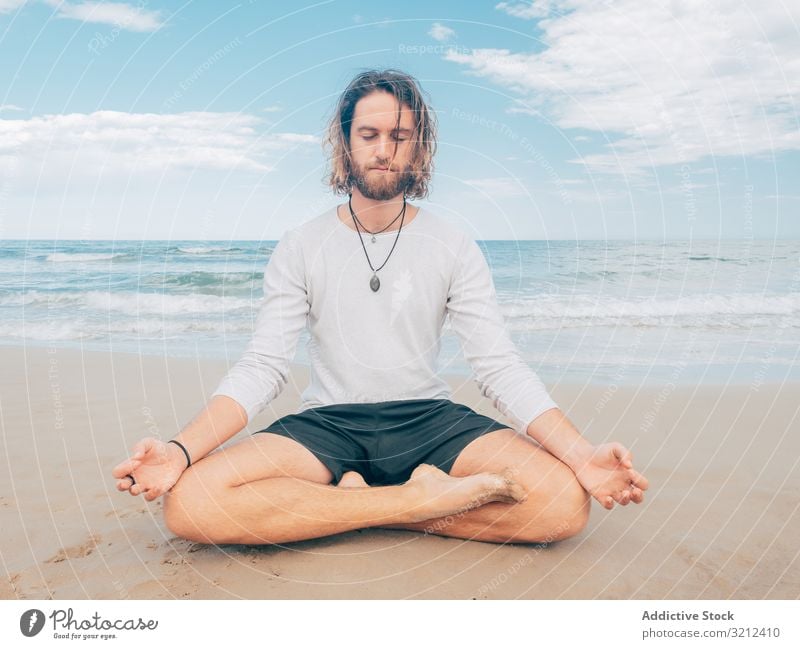 Man training yoga on beach man rest harmony asana exercise seashore energy meditation equilibrium stretch zen relax balance sport lifestyle calm male bearded