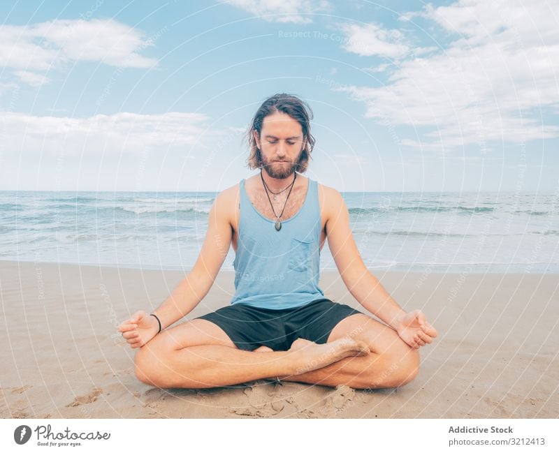 Man training yoga on beach man rest harmony asana exercise seashore energy meditation equilibrium stretch zen relax balance sport lifestyle calm male bearded