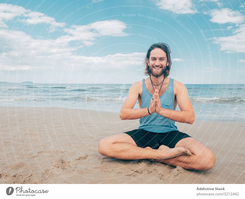 Man training yoga on beach man rest harmony asana exercise seashore energy meditation equilibrium stretch zen relax balance sport lifestyle calm male bearded