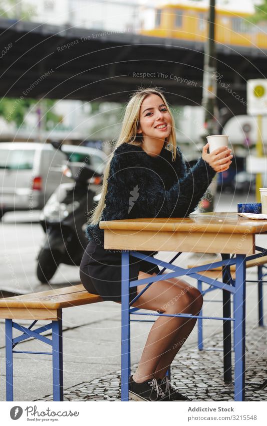 Beautiful woman drinking coffee in street cafe berlin blonde cheerful smile young beautiful fashion stylish elegant attractive casual hair model female trendy