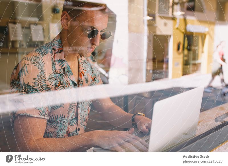 Man working on browsing laptop man freelance concentrated focused thoughtful using glass occupation cafe profession handsome adult male communication home