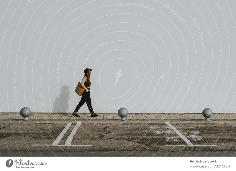 Woman with bag walking along parking lot woman attractive young empty stylish fashion direction model elegant lifestyle beautiful female trendy gorgeous