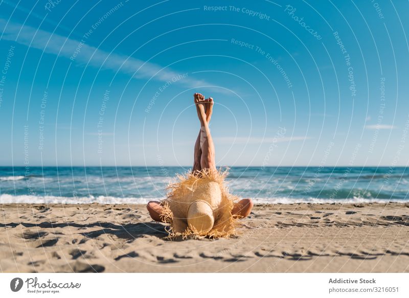 Woman in big hat lying on sandy beach woman slim tanned water attractive summer leisure athletic sporty hide body seaside wavy covered straw hat female