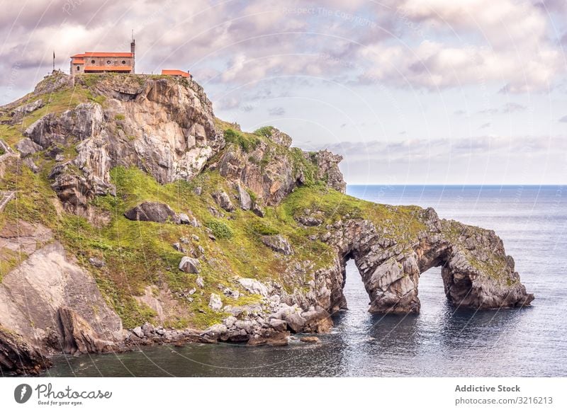 Building on top of stony island among water building seaside calm rocky cloudy sky arch coast nature scenic picturesque landscape travel vacation peaceful