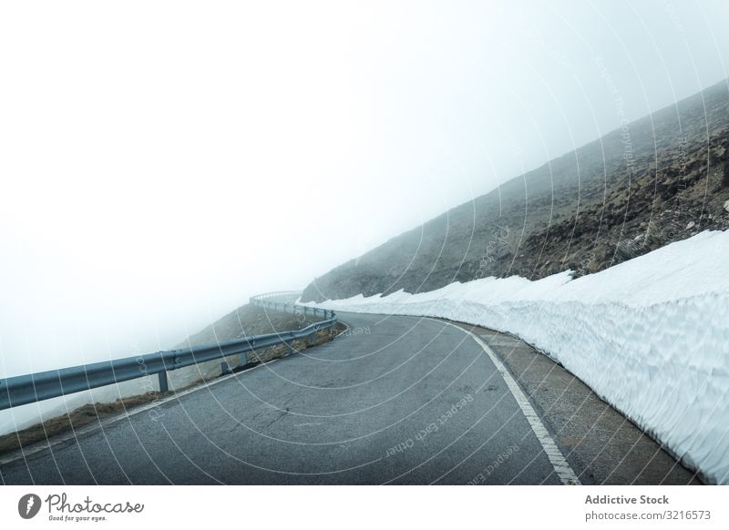 Road in foggy mountains road travel nature landscape weather mist haze vague slope terrain trip journey tourism adventure gray snow cold cool highway trail