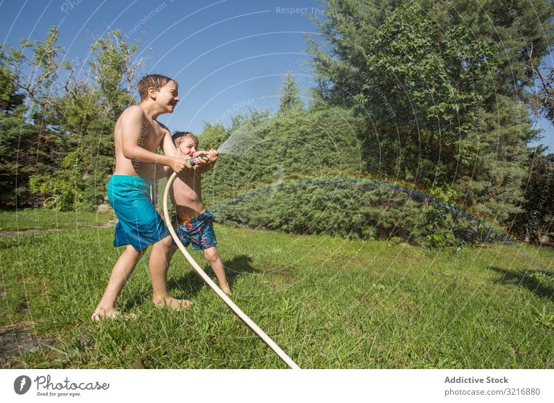 Little kids in swimwear having fun with splashing water children summer playing happy holding lifestyle leisure recreation holiday childhood joy enjoyment