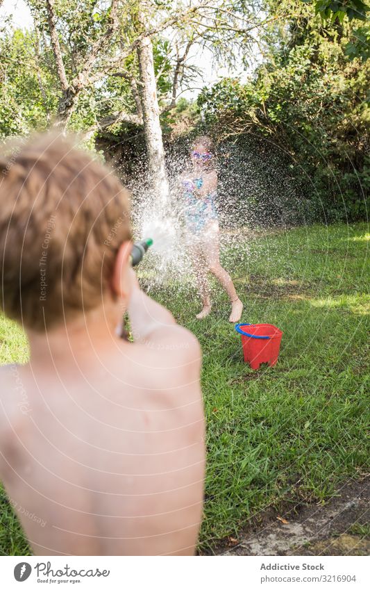 Little kids in swimwear having fun with splashing water children summer playing happy lifestyle leisure recreation holiday childhood joy enjoyment amusement