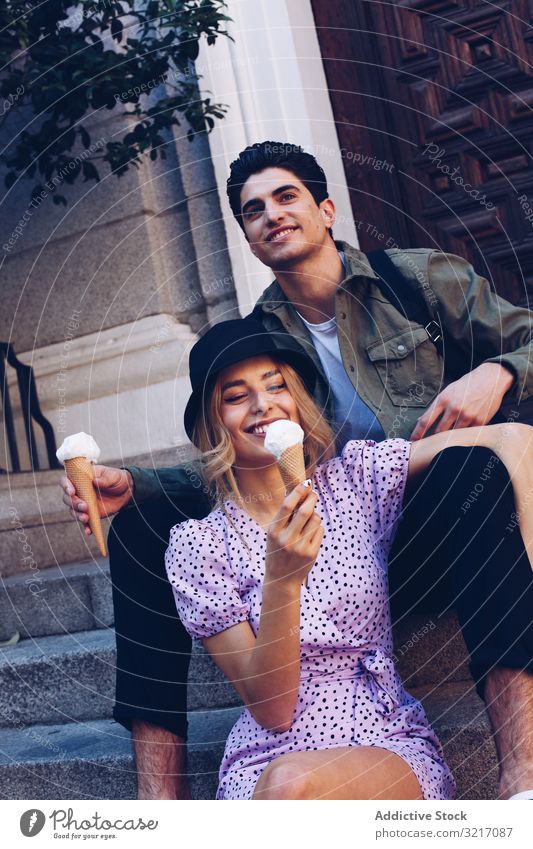 Happy couple feeding each other by ice cream happy cheerful woman cornet girlfriend boyfriend eating food fun lifestyle love dating flirting having fun