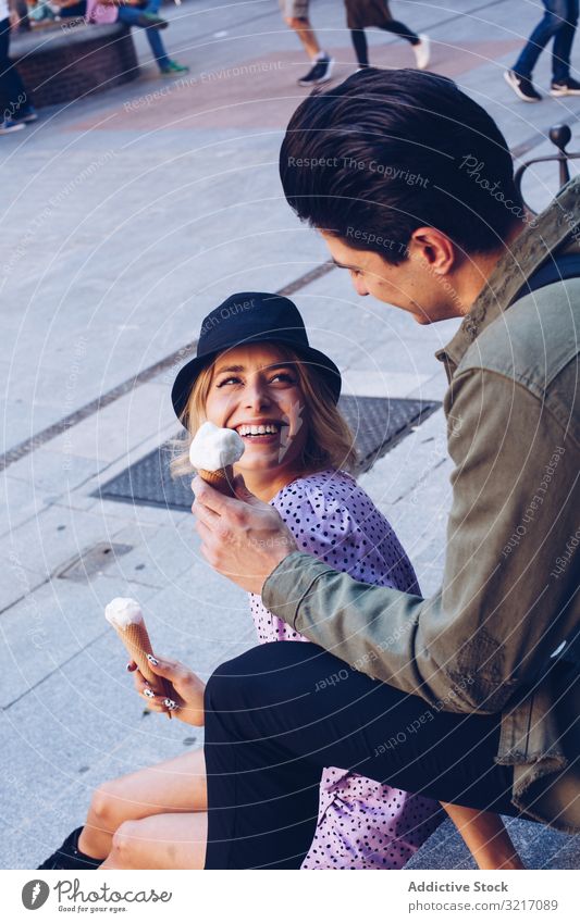 Happy couple feeding each other by ice cream happy cheerful woman cornet girlfriend boyfriend eating food fun lifestyle love dating flirting having fun