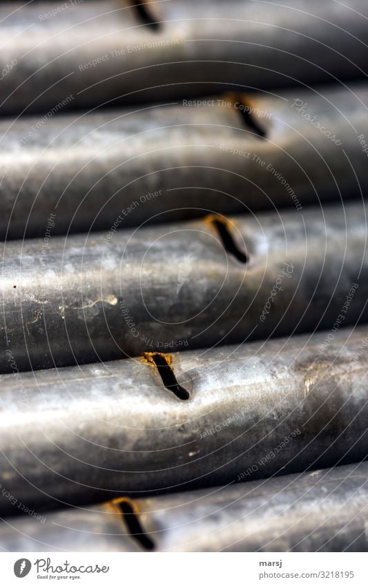 Galvanized iron tubes with slots Iron Iron-pipe Slit Rust zinc-plated Exterior shot worn-out sorted out Parallel Shallow depth of field Dented Scrap metal